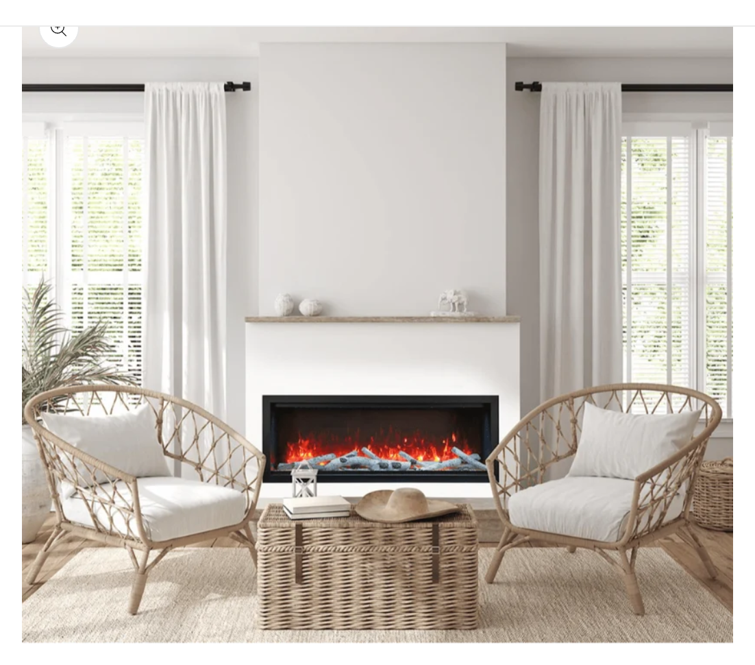 electric fireplace burning with birch logs in a whit surround in a living room with chairs and a basket