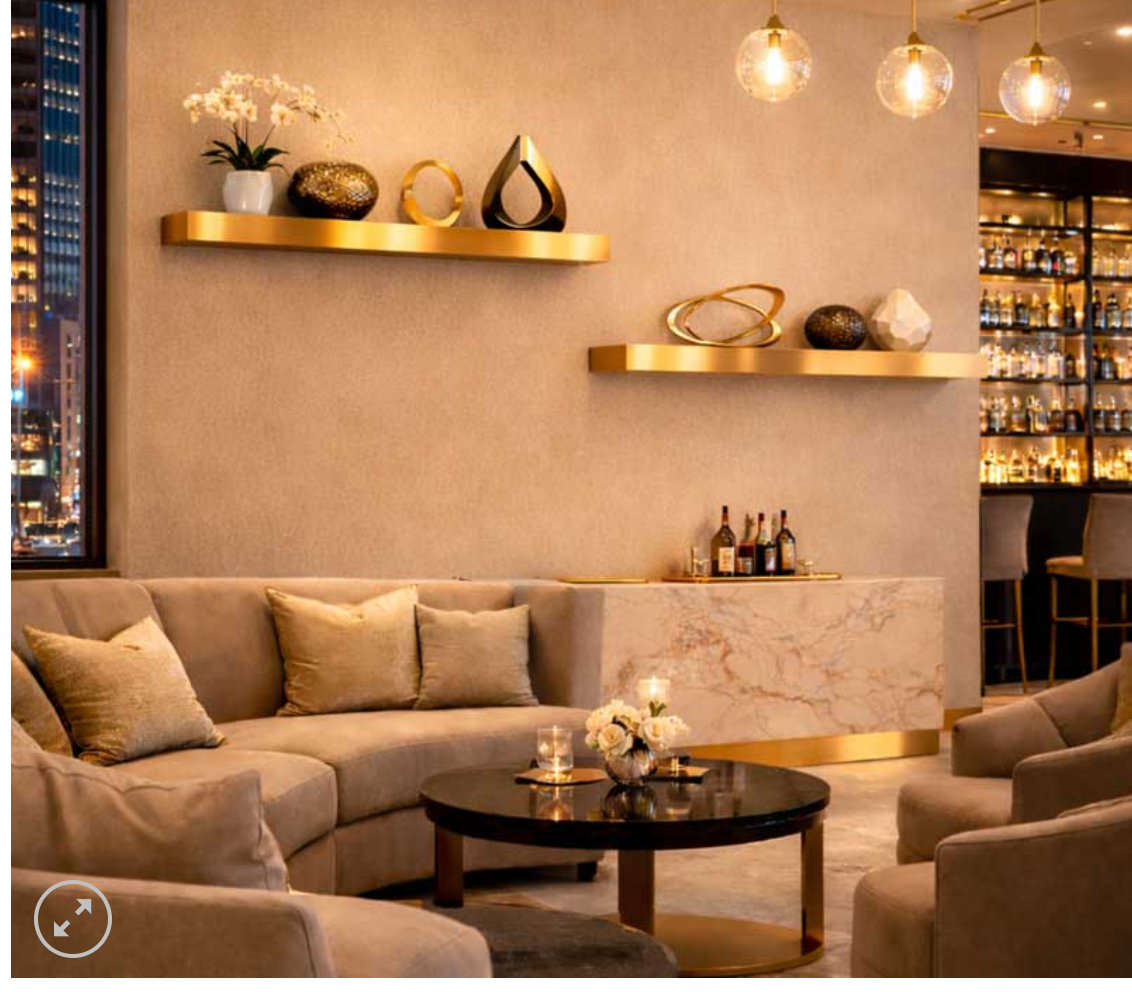 two shelves in a bar with sofa and table and lighting in the space.