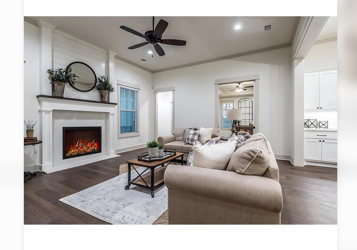 electric fireplace in a white surround in a living room wht a sofa and a coffee table