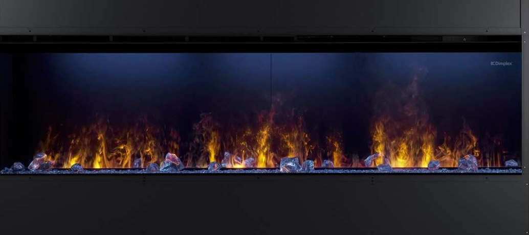 A modern linear fireplace with a black frame, featuring realistic orange and yellow flames dancing over clear decorative stones against a dark background.