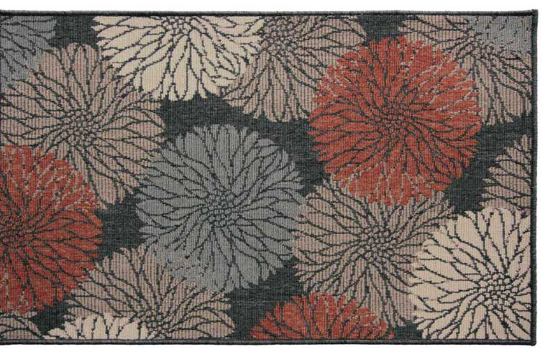 A rectangular area rug featuring a bold floral pattern with large daisy-like blooms in rust red, gray, and cream on a dark charcoal background.