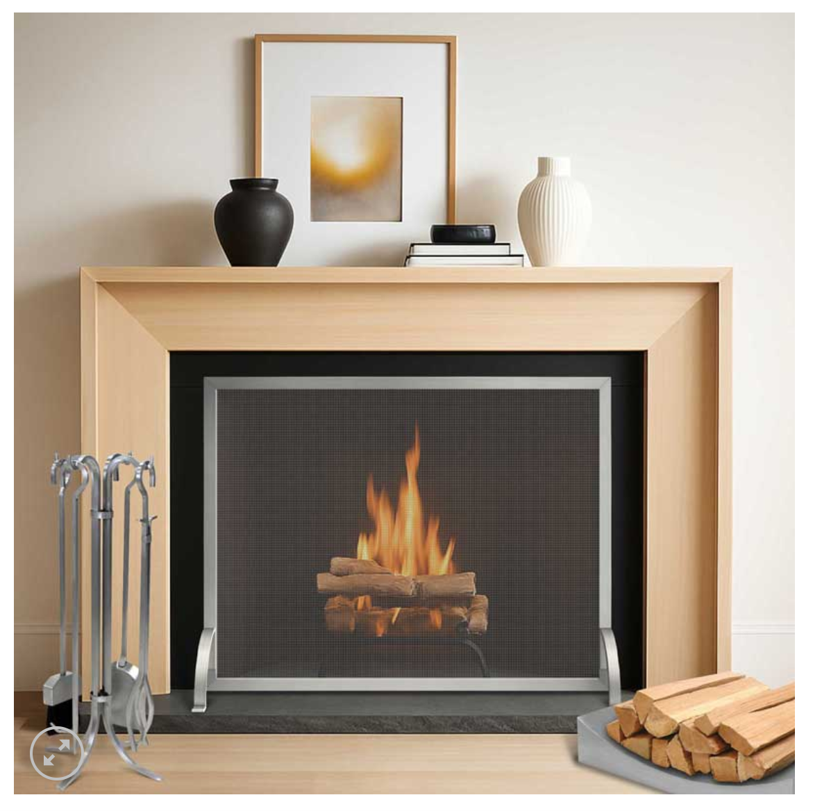 wood holder on the right side of a burning fireplace showin brushed stainless steel firescreen and tool set