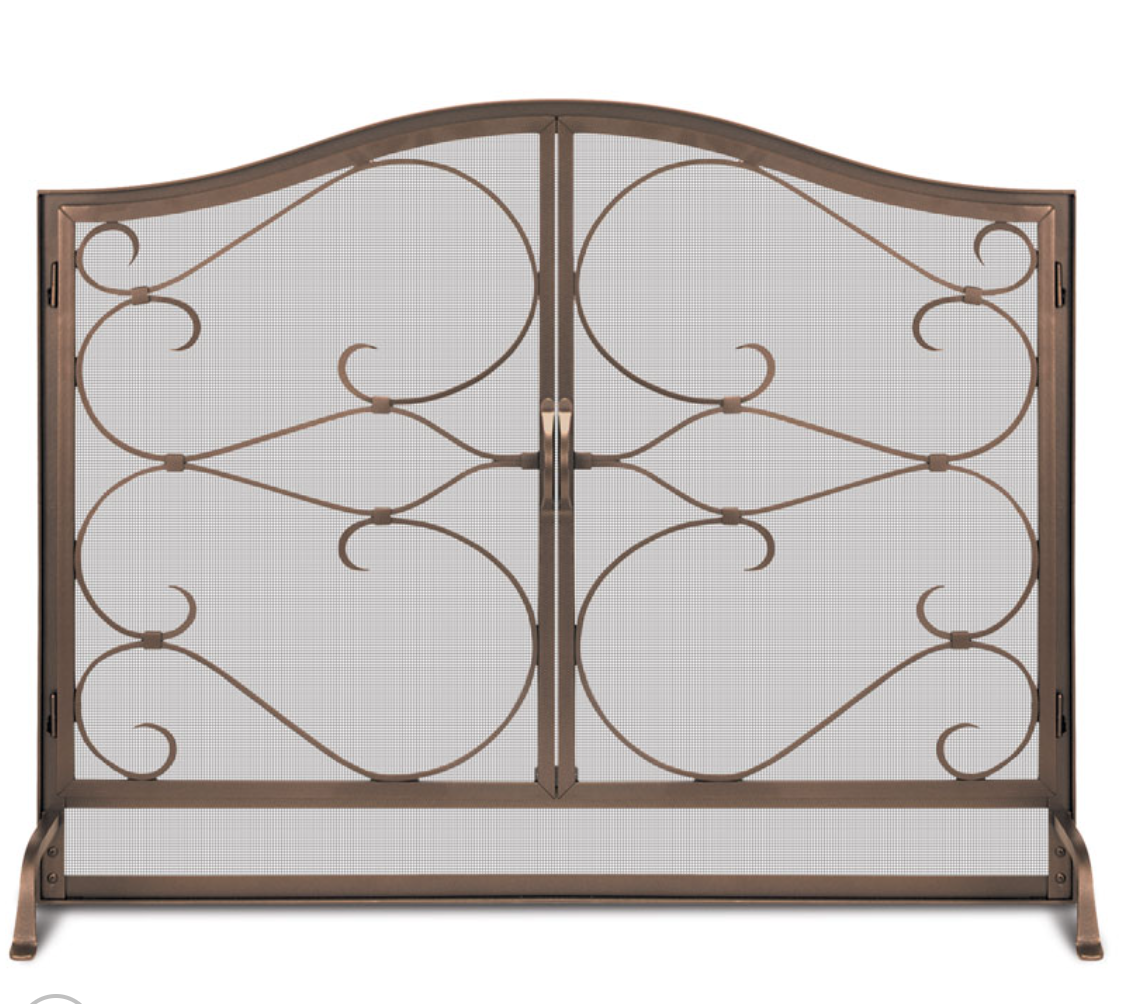 A decorative metal fireplace screen with an ornate scrollwork design and mesh panels, shown on a plain white background.