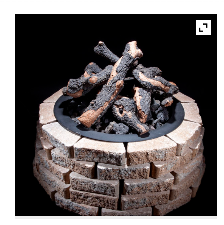 fire pit showing logs in a brick surround  on a black background