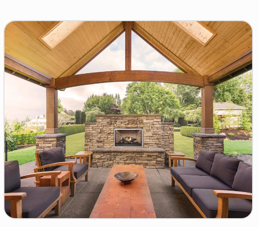 outdoor gas fireplace built in stone wall with outdoor furniture in front of it.
