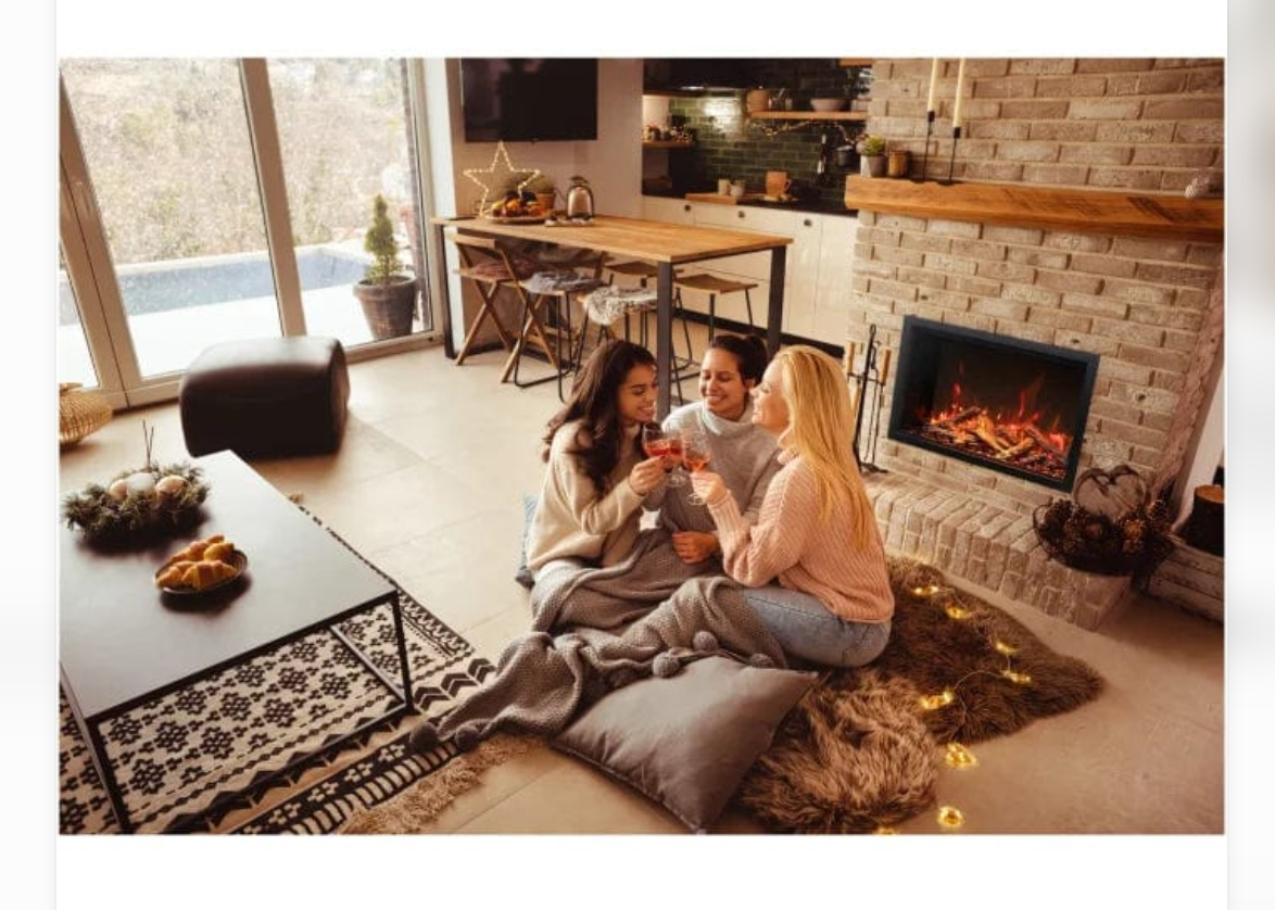 a group of women in front of the fireplace built into a stone surround in a living/dining area