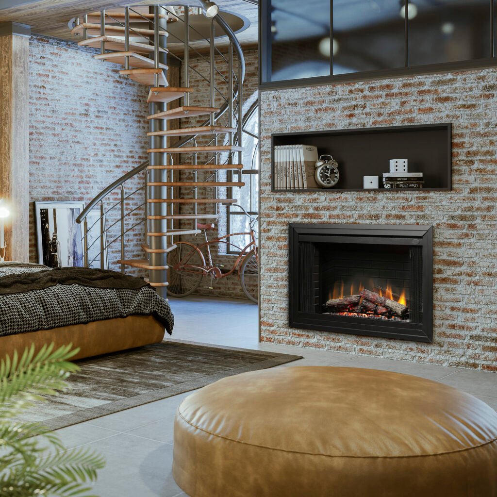 A modern black fireplace insert with a glowing fire, set into a brick wall in a stylish loft room with a spiral staircase, leather pouf, and bed.