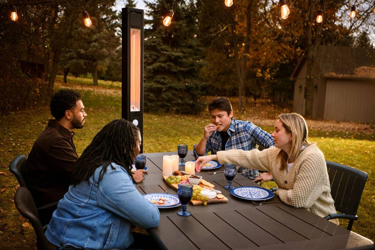 People sitting around a table outdoors with a patio heater in the background