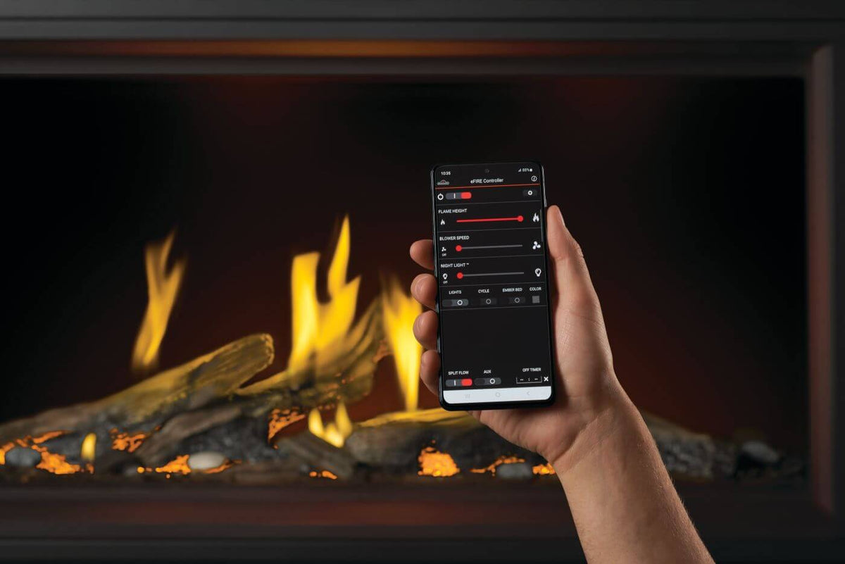 Hand holding a smartphone with app interface in front of a fireplace