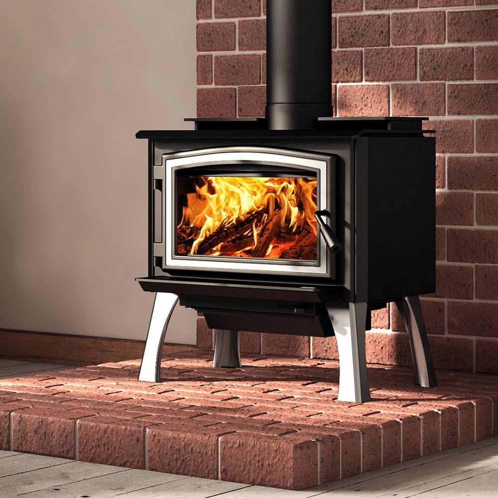 A black wood-burning stove with a silver-trimmed glass door and visible flames, set on a brick hearth in front of a red brick wall.